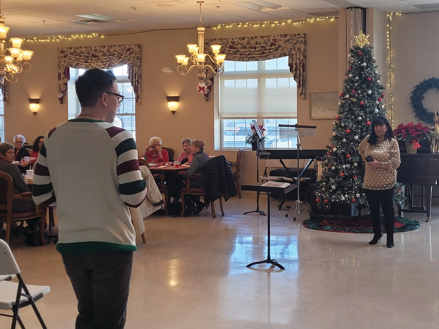 CHRISTMAS PARTY: Members of the Johnston Senior Center had drinks and snacks prior to a rousing performance by the Johnston High School Chorus. Senior Center Director Matt Bolton introduced the chorus to the audience.